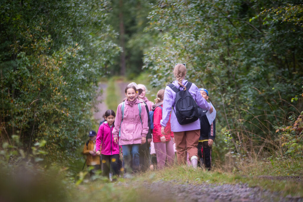 Iloisia kuudesluokkalaisia lapsia metsätiellä. Kuva: Vilma Issakainen